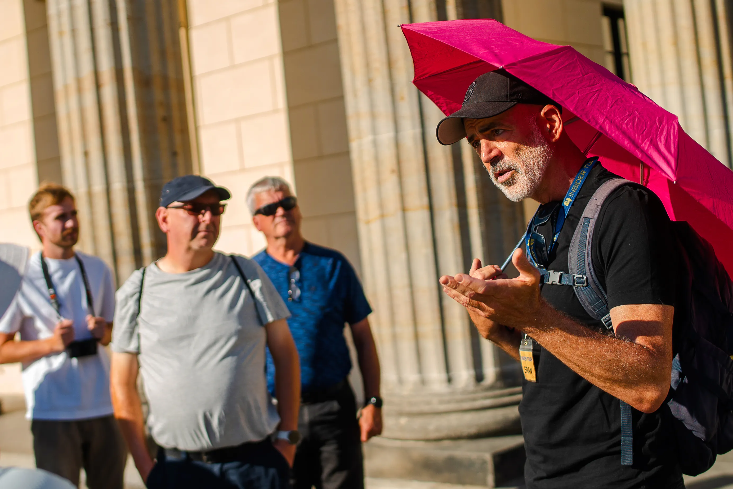 Tour guide leading a group near historical columns in Berlin during a Third Reich and Cold War walking tour.