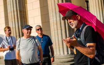 Tour guide leading a group near historical columns in Berlin during a Third Reich and Cold War walking tour.