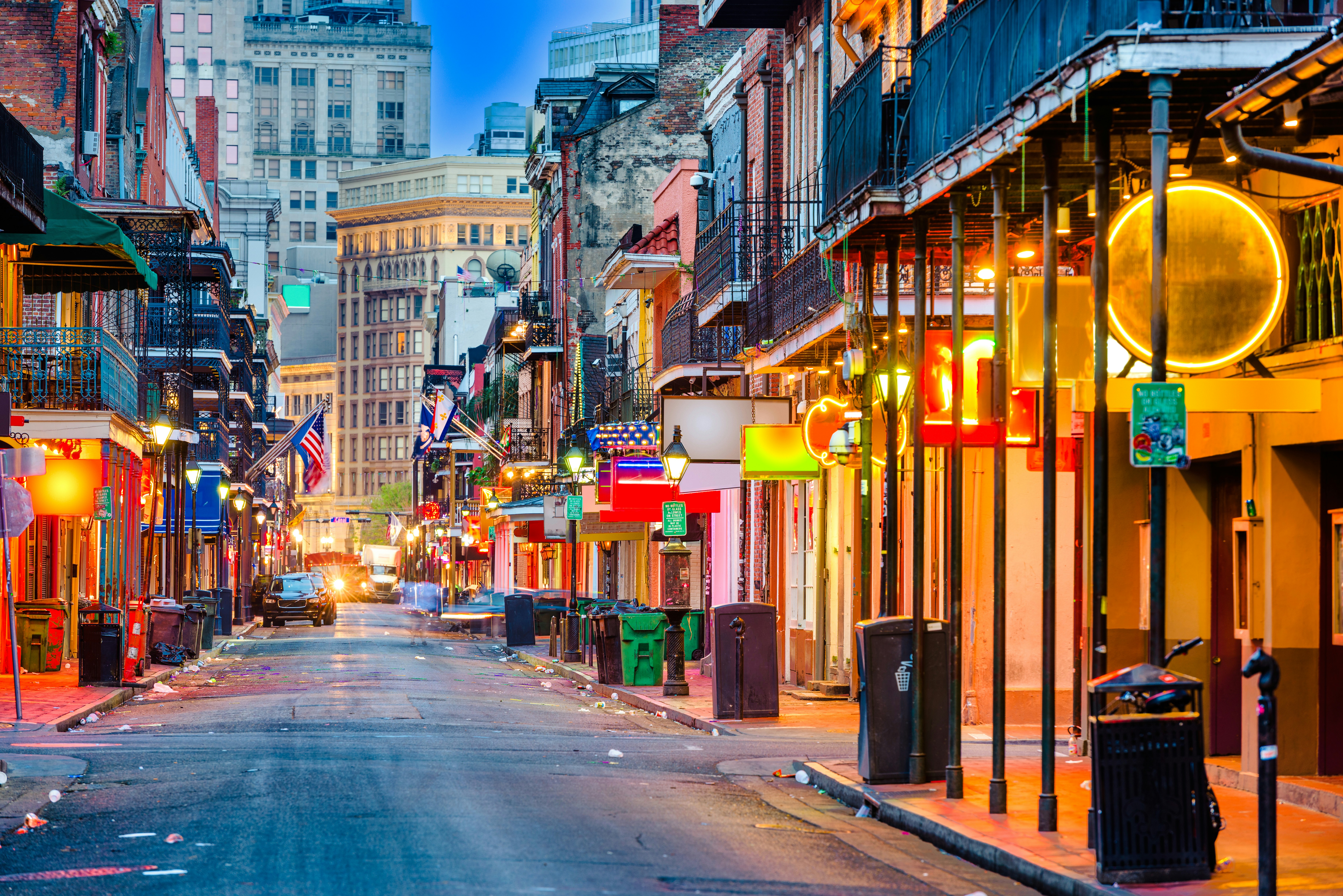 Bourbon Street in New Orleans with vibrant bars and restaurants at twilight.