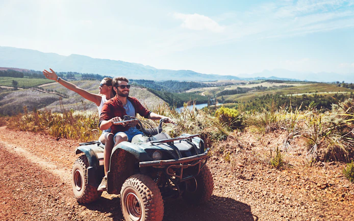 Couple riding quad bike on dirt trail during safari in Antalya.