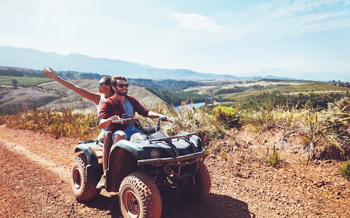 Couple riding quad bike on dirt trail during safari in Antalya.