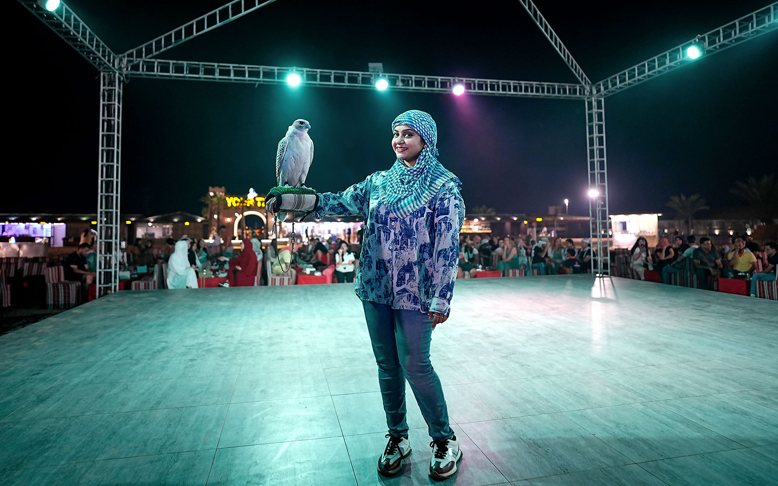Lady holding a falcon during a Dubai desert safari experience.