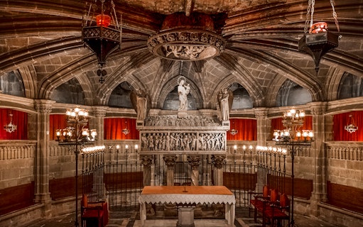 Interior of the Cathedral of Barcelona with ornate altar and statues.