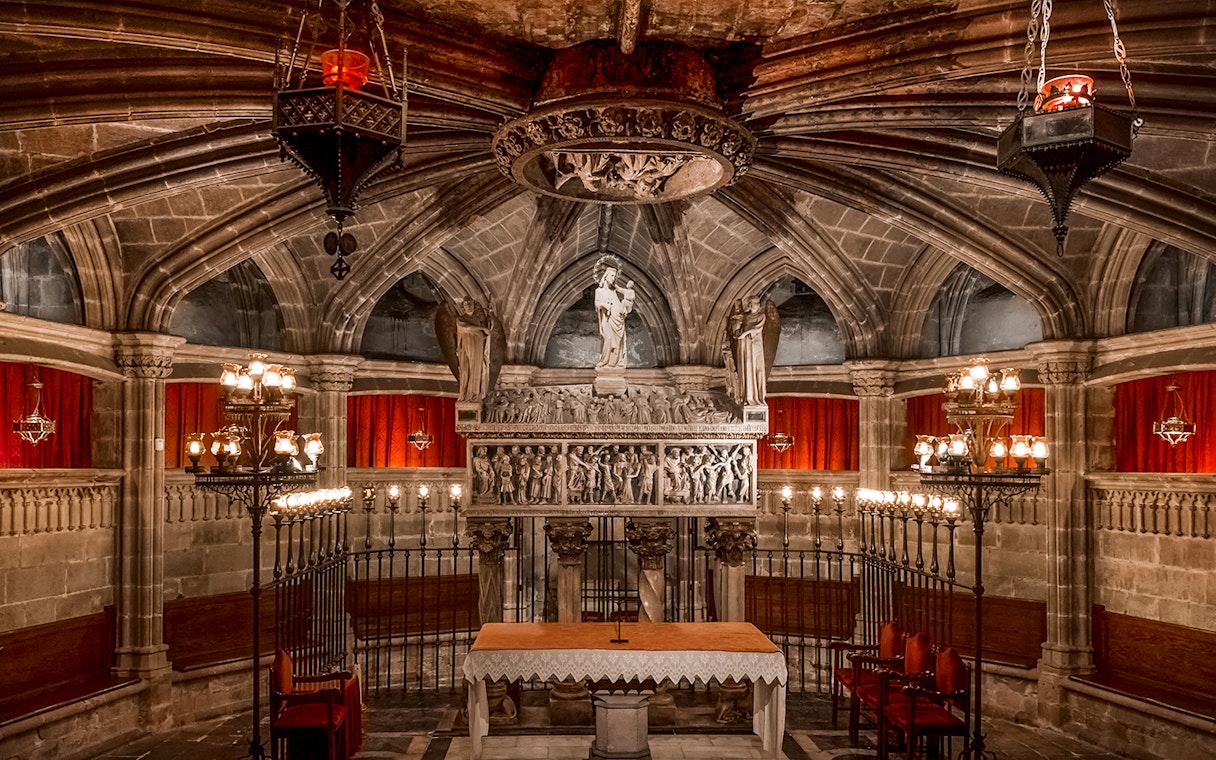 Interior of the Cathedral of Barcelona with ornate altar and statues.