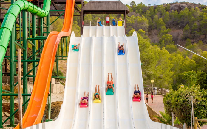 Visitors sliding down splash slide at Aqualandia Benidorm, Spain.