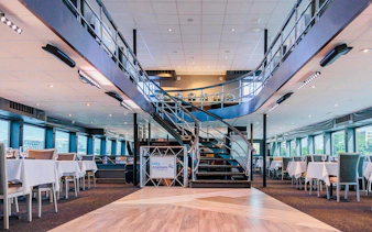 Interior of the Signature Bottomless Mimosa Brunch Cruise ship in Washington DC with dining tables.