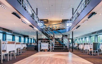 Interior of the Signature Bottomless Mimosa Brunch Cruise ship in Washington DC with dining tables.