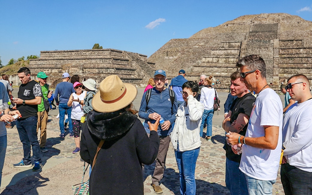 Tour group exploring Teotihuacán pyramids during balloon flight excursion.