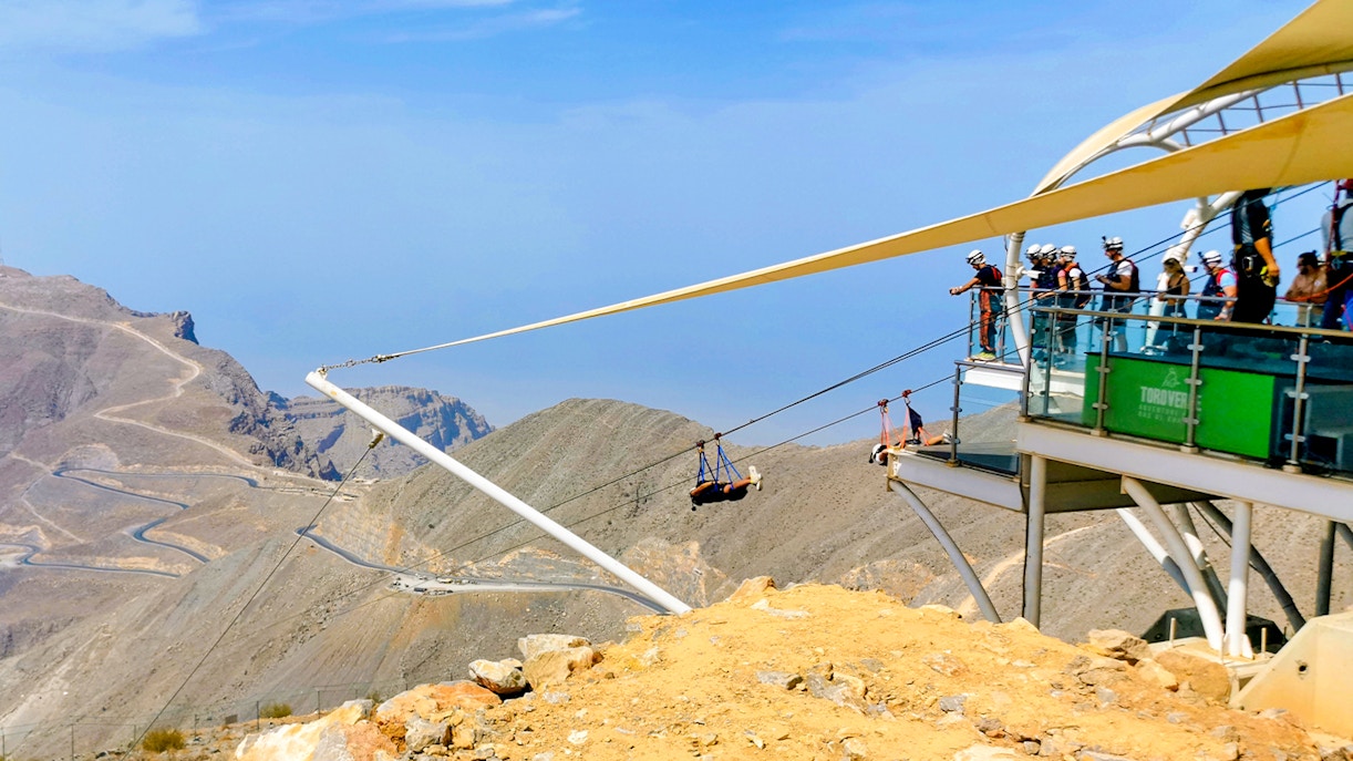 Jebel Jais zipline over rocky mountain landscape in Ras Al Khaimah, UAE.