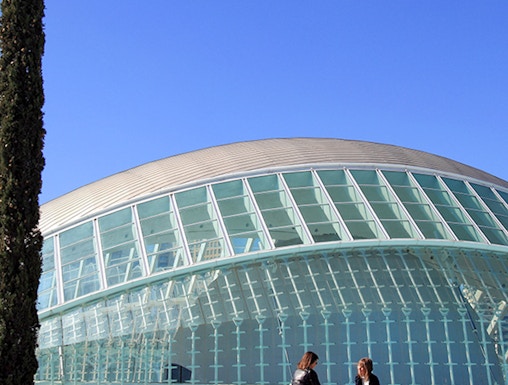People sitting by the Hemisfèric building at City of Arts and Sciences, Valencia.
