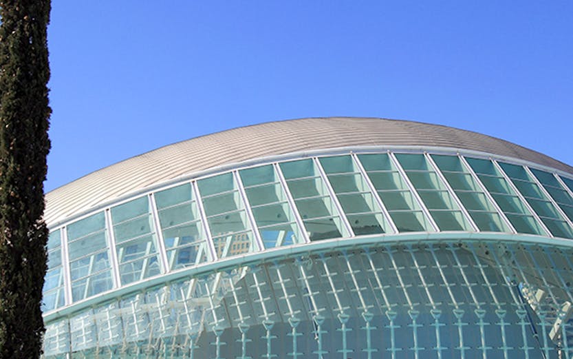 People sitting by the Hemisfèric building at City of Arts and Sciences, Valencia.