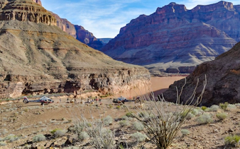 Helicopter landing at Grand Canyon West with tourists exploring the canyon landscape.