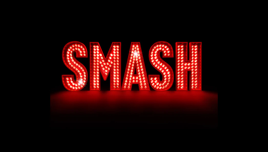 Illuminated red marquee letters spelling "SMASH" against a dark background.