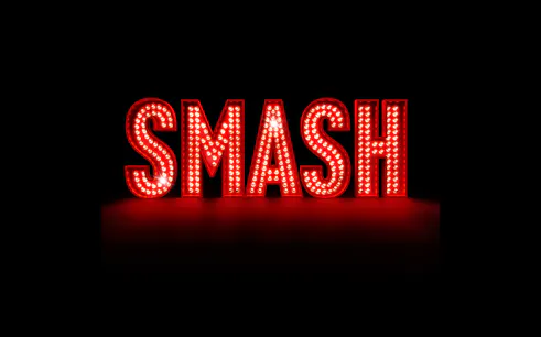Illuminated red marquee letters spelling "SMASH" against a dark background.