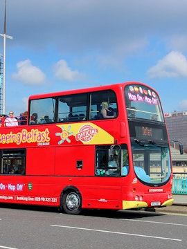 Open-top red tour bus for city sightseeing in Belfast.