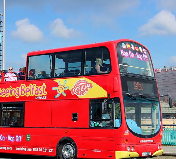 Open-top red tour bus for city sightseeing in Belfast.