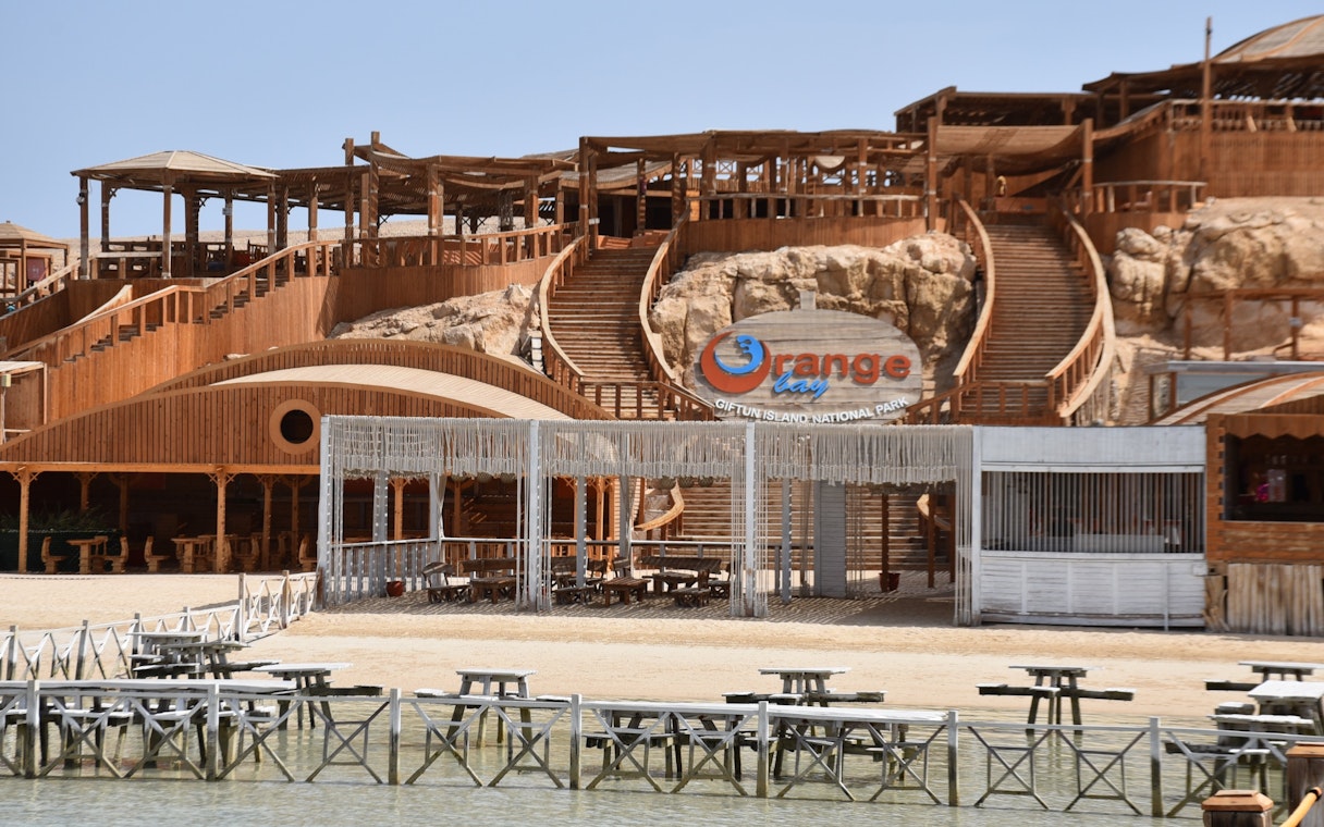 Orange Bay entrance with wooden structures and seating area, Red Sea near Hurghada, Egypt.