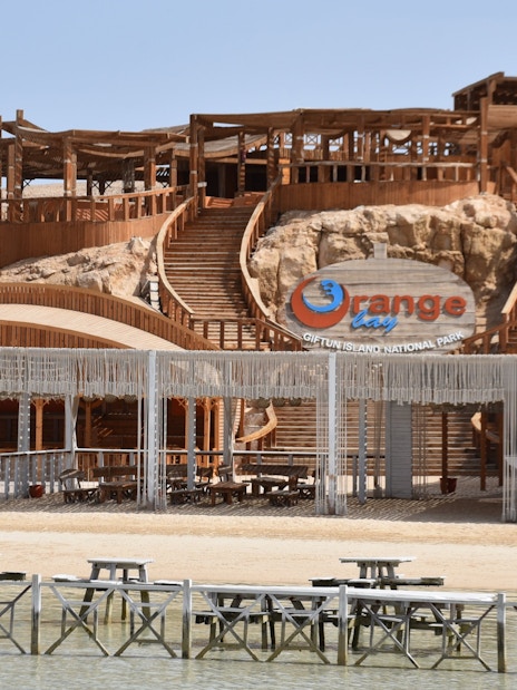 Orange Bay entrance with wooden structures and seating area, Red Sea near Hurghada, Egypt.