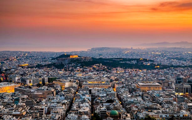 Acropolis and Parthenon at sunset, overlooking Athens cityscape.
