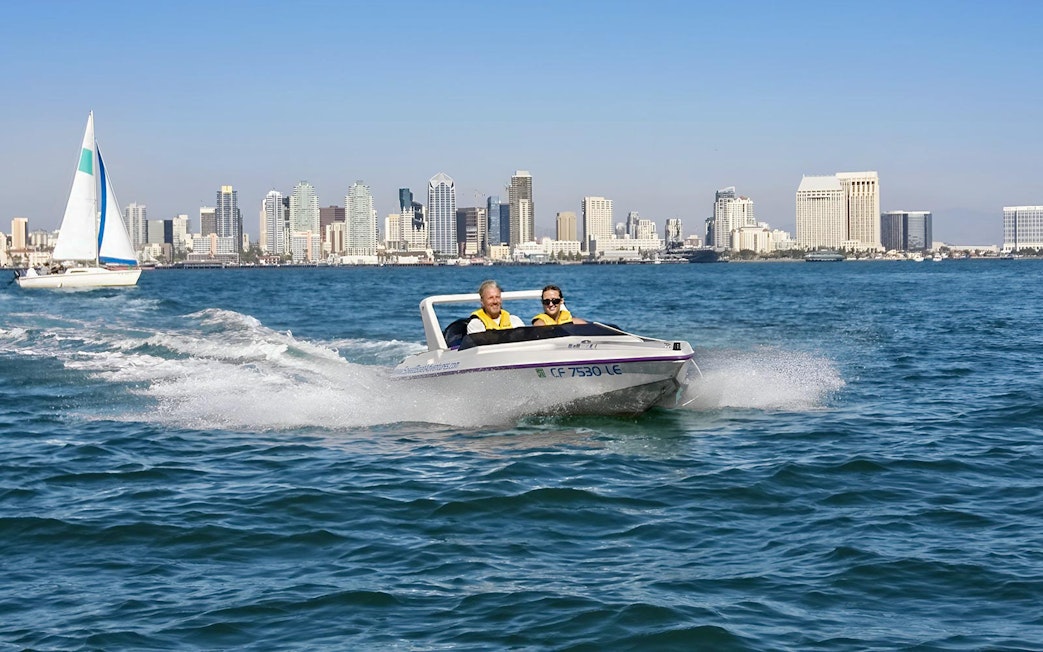 Speedboat on San Diego Bay with city skyline in the background, part of San Diego Explorer Pass.