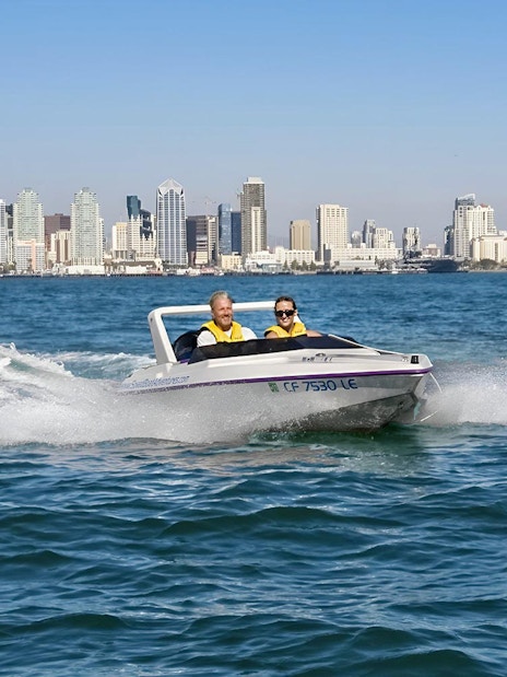 Speedboat on San Diego Bay with city skyline in the background, part of San Diego Explorer Pass.