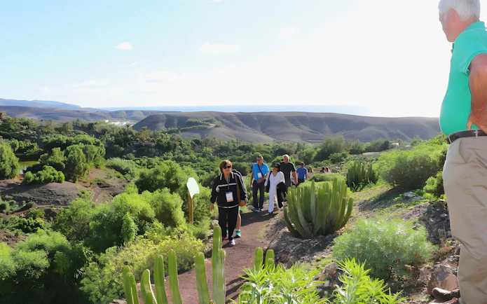 Group hiking through lush landscape on Oasis Wildlife trek.