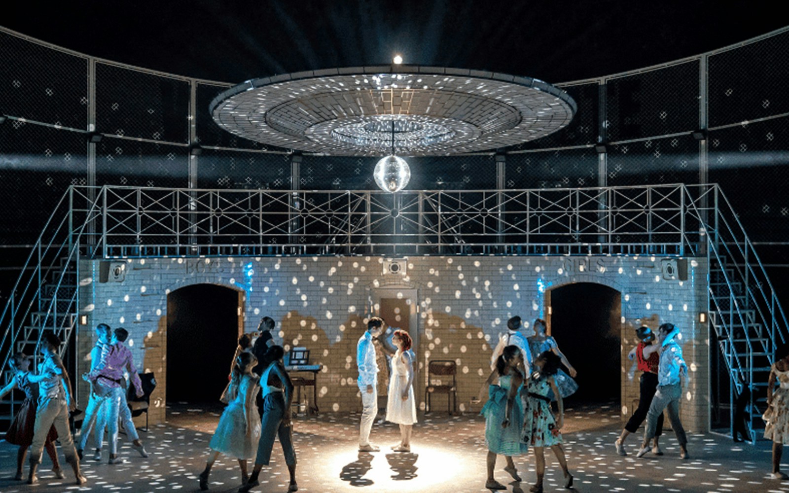 Dancers perform under a disco ball in Matthew Bourne's Romeo and Juliet.