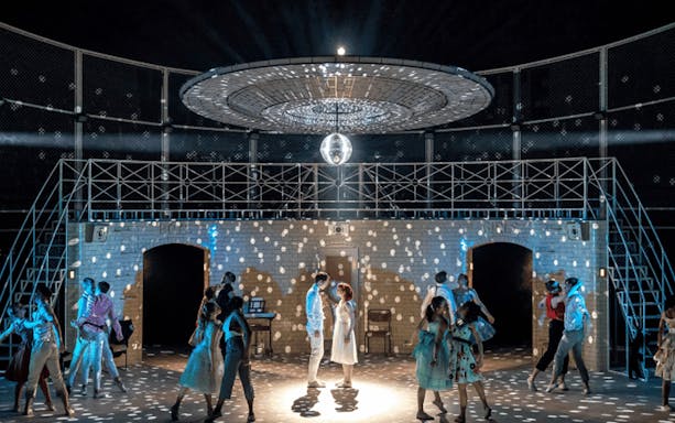 Dancers perform under a disco ball in Matthew Bourne's Romeo and Juliet.