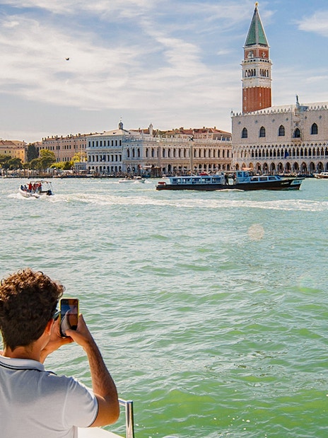 Visitor photographing St. Mark's Campanile from a Venice Panoramic Boat Tour.