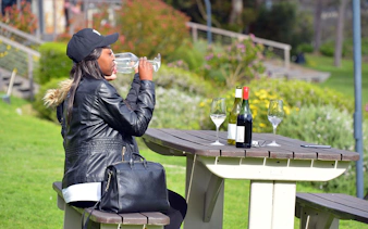 Tourist tasting wine at a picnic table in Constantia, South Africa.