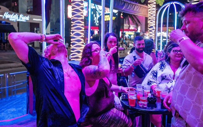 Group enjoying drinks at Coco Bongo Congo Bar with neon lights in the background.