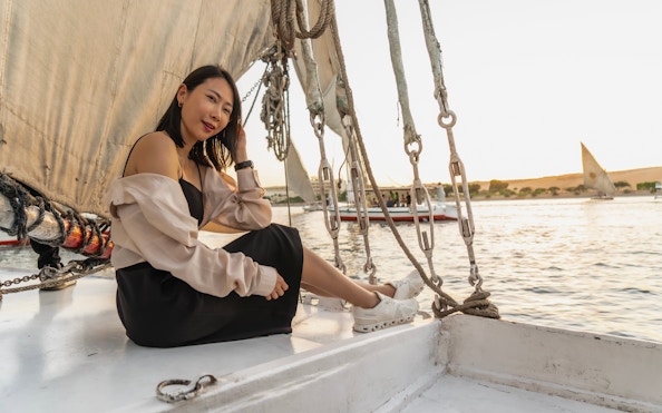 Woman enjoying a felucca boat ride on the Nile River, Cairo.