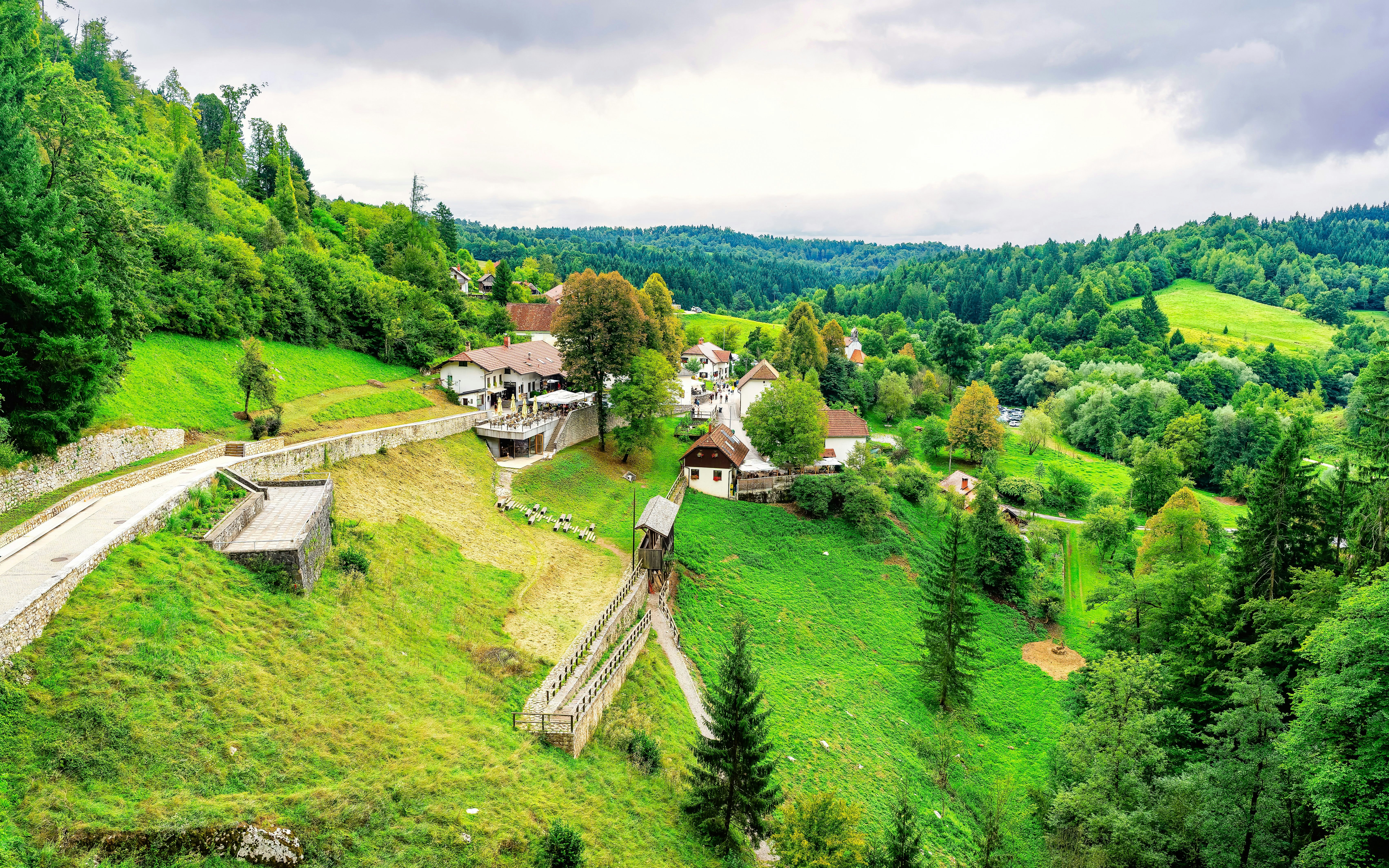 Predjama Castle landscape with lush greenery and surrounding forest in Slovenia.