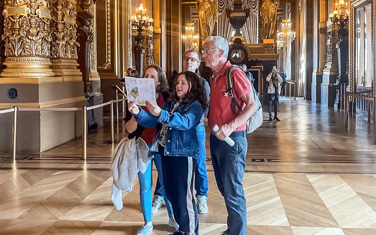 Visitors exploring Garnier Opera during Arsene Lupin immersive game in Paris.