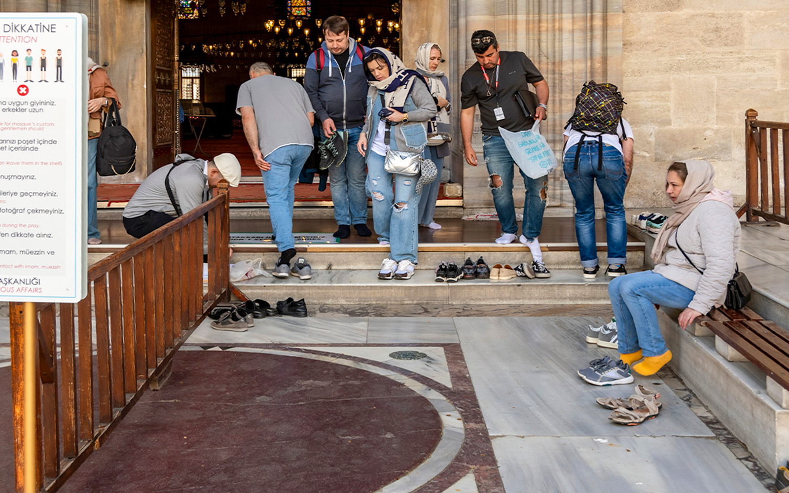 Visitors removing shoes at Süleymaniye Mosque entrance, Istanbul.