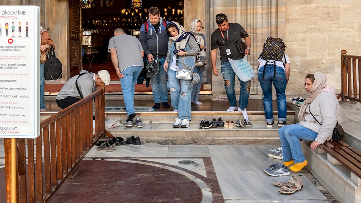 Visitors removing shoes at Süleymaniye Mosque entrance, Istanbul.