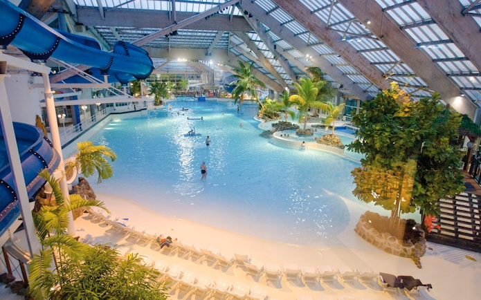 Indoor water park with wave pool and slides at Aquaboulevard de Paris.