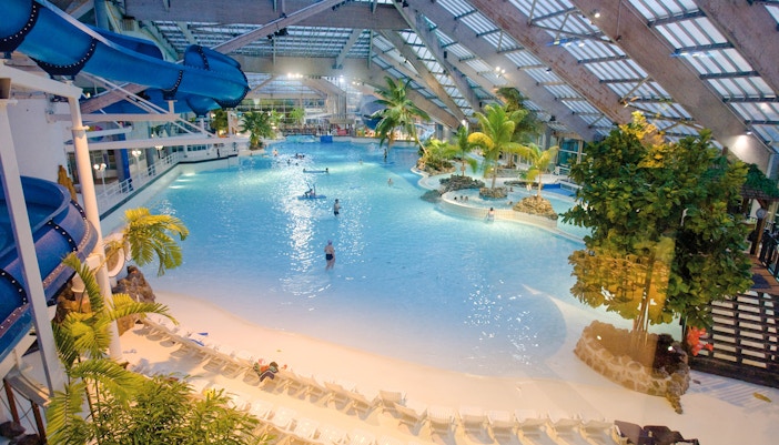Indoor water park with wave pool and slides at Aquaboulevard de Paris.