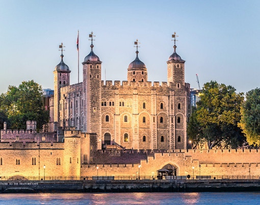 Tower of London illuminated at night, view from the Thames River.