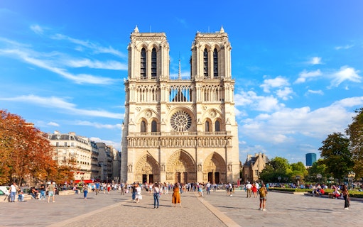 Notre Dame de Paris facade with tourists in the foreground, Paris, France.