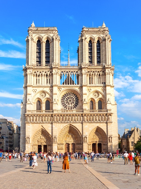 Notre Dame de Paris facade with tourists in the foreground, Paris, France.