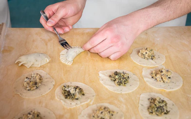 Filling and sealing dumplings in a Polish dumplings cooking class.