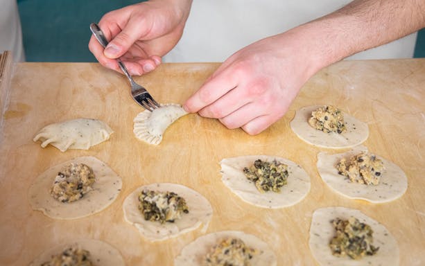 Filling and sealing dumplings in a Polish dumplings cooking class.