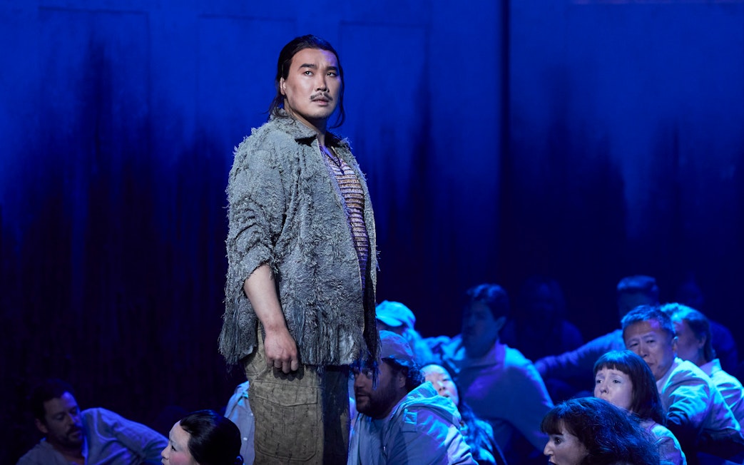 Performer on stage during Turandot show in Sydney, surrounded by cast members.