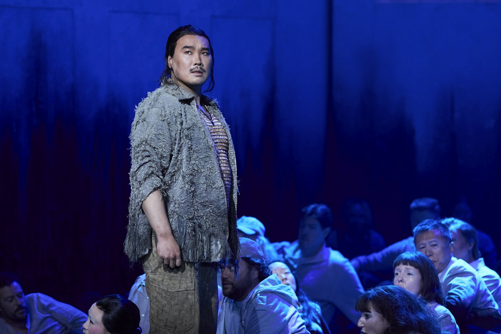 Performer on stage during Turandot show in Sydney, surrounded by cast members.