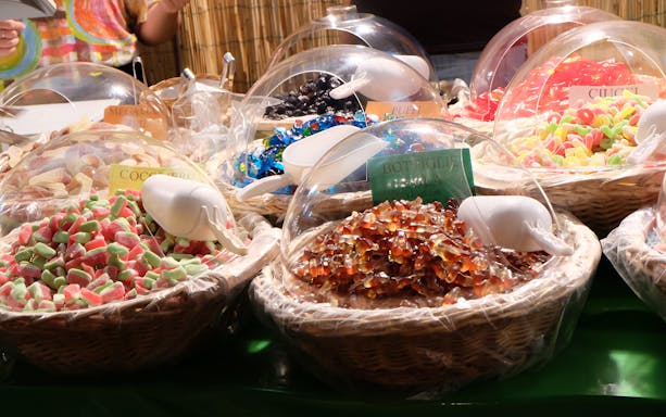Assorted candies in baskets at a market stall during the Sunset Food Tour in Trastevere.