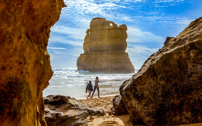 Tourists walking on Gibson Steps beach with rock formations, Great Ocean Road tour.