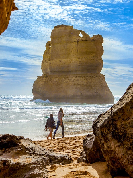 Tourists walking on Gibson Steps beach with rock formations, Great Ocean Road tour.