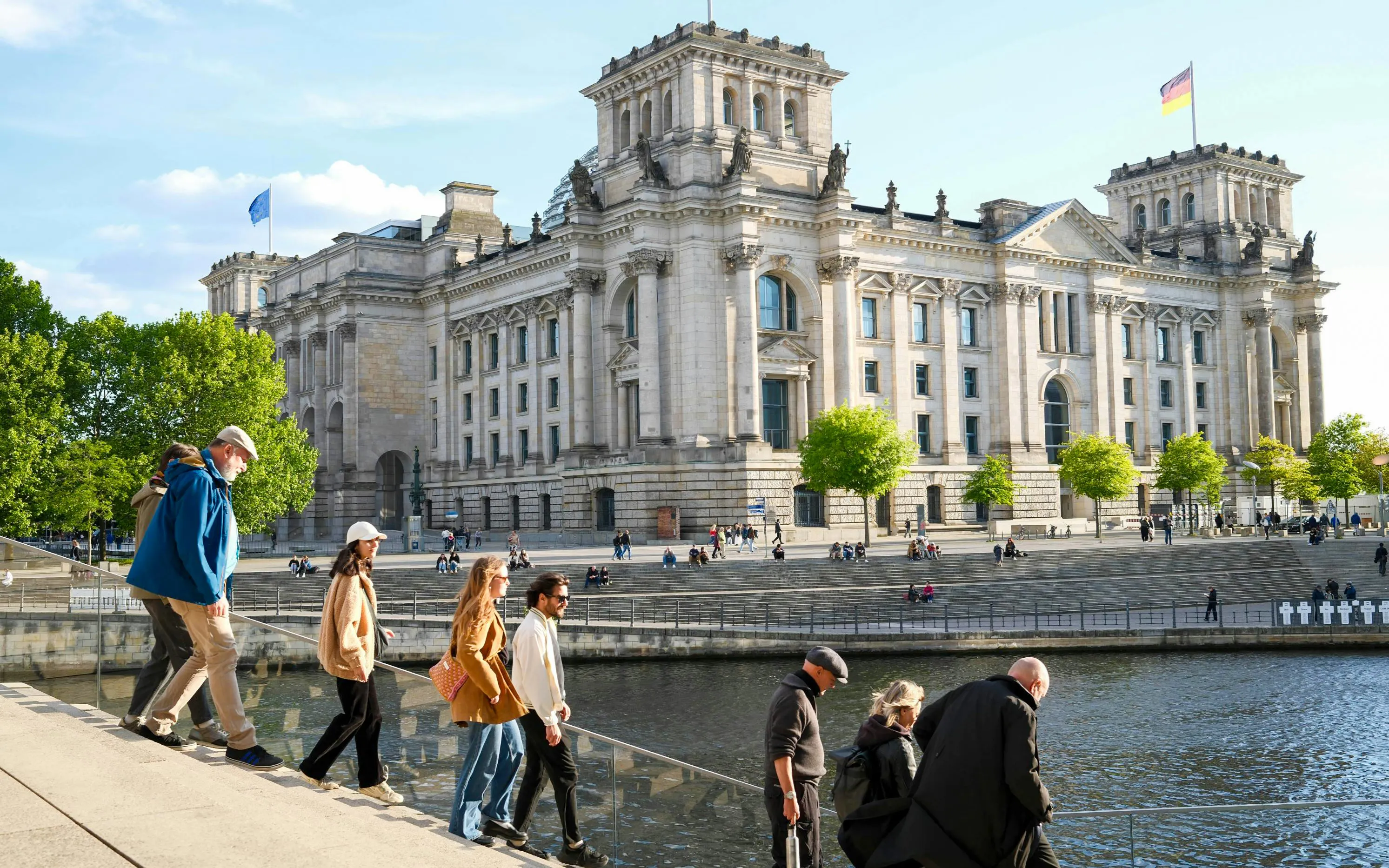 Guided tour group walking near the Reichstag building in Berlin's Government District.