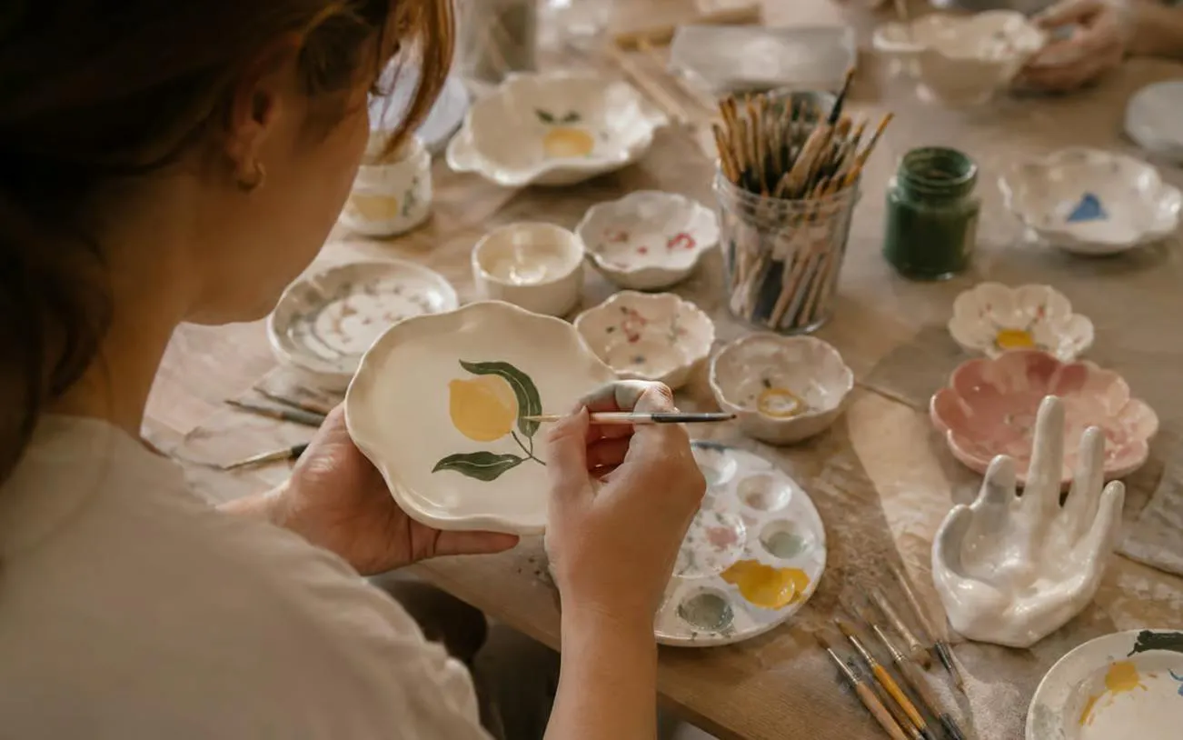 Sculpting and painting clay dish with lemon design at Krakow workshop.